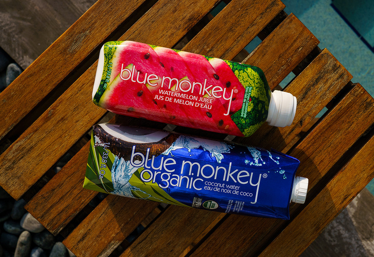 Watermelon Juice and Coconut Water side by side on a poolside table